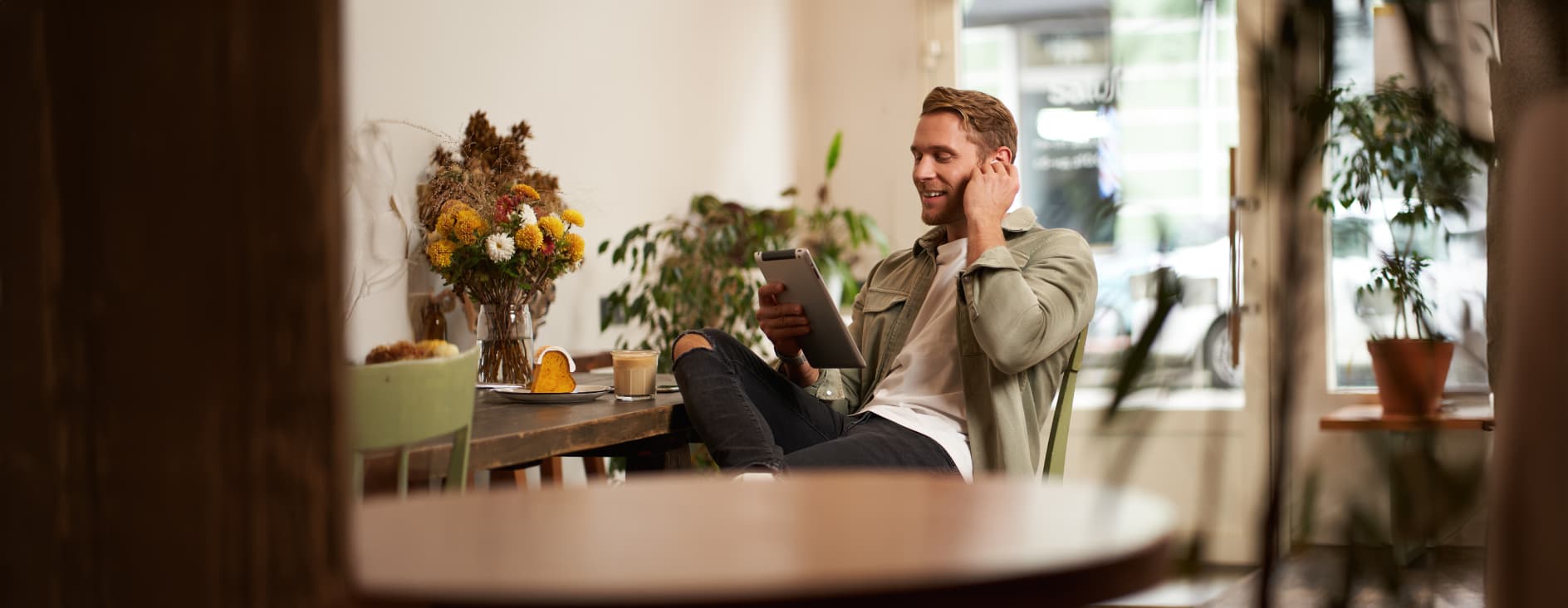 Person working on a tablet in a sunlit cafe